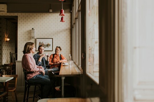 Diverse friends having morning coffee at a cafe - Powered by Adobe