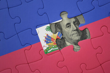 puzzle with the national flag of haiti and usa dollar banknote. finance concept - obrazy, fototapety, plakaty