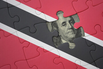 puzzle with the national flag of trinidad and tobago and usa dollar banknote. finance concept