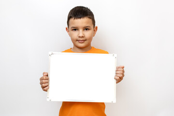 A guy in an orange t-shirt on a white background is holding a blackboard with a white background.