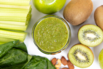 Green smoothie of celery, kiwi, green apple and spinach in a glass