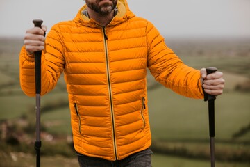 Man wearing orange puffer jacket, outdoor outfits © Rawpixel.com