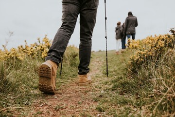 Hiking boots closeup, man trekking on hill