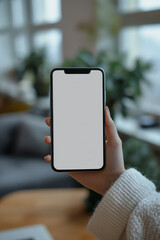 Mockup of an iPhone with a white screen, hand holding the iPhone, indoors