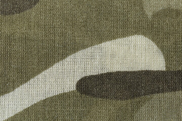 A close up of a piece of camouflage fabric. The fabric is a mix of brown and white, with a pattern...