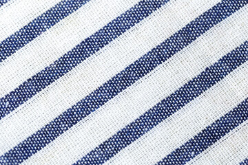 Texture of a blue and white striped fabric. The stripes are diagonal and the background is white