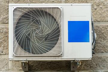 Outdoor air conditioning unit. A large modern air conditioner on the wall of an apartment building....