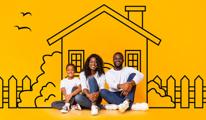Cute African American family father mother and daughter sitting over drawn on yellow wall house, smiling at camera. Real estate, mortgage concept