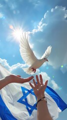 A man's hand reaches out to a white dove against the background of the sky and the waving Israeli flag