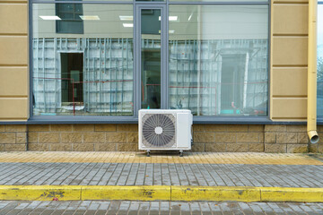 Outdoor air conditioning unit. A large modern air conditioner on the wall of an apartment building....