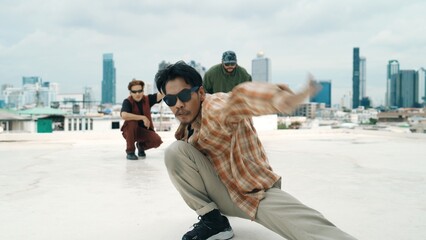 Professional hispanic break dancer practice B boy dance while multicultural friends at roof top....