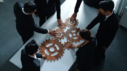 Top view of smart business people gather wooden cog together at meeting. Group of project manager...
