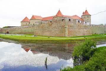 Romanian fortress Fagaras and its reflection in the waters of the moat