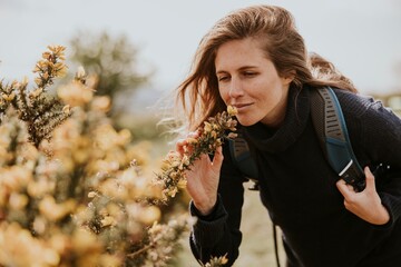 Female hiker smelling flowers, outdoor activity photo