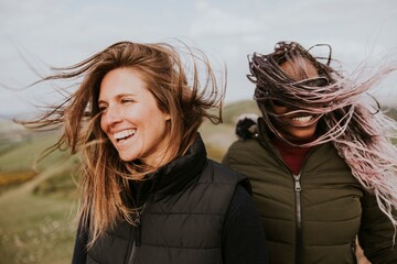 Smiling women with windy hair, outdoor activity