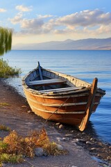 Obraz premium Serene lakeside scene with old wooden boat