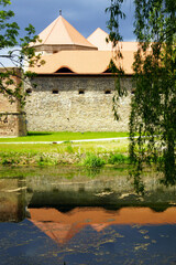 Fragment of the Romanian fortress Fagaras: a defensive wall with a palace behind it and their...
