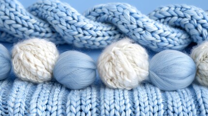   A collection of yarn balls atop a blue knitted blanket on a blue surface