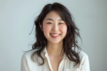 Fototapeta premium Radiant Asian Woman Poses in Bright Studio for Promotional Brand, Exuding Confidence and Energy