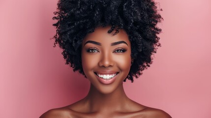 Fototapeta premium A tight shot of a woman's expression, her afro hairstyle framing the image, against a backdrop of a pink wall