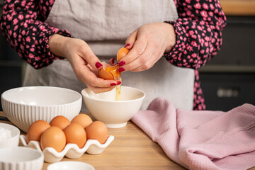 In a cozy kitchen, a cook skillfully separates an egg yolk from the white, surrounded by essential...
