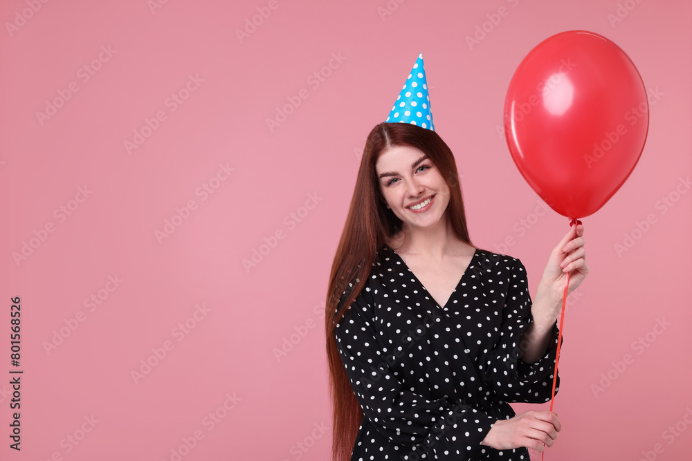 Poster Happy woman in party hat with balloon on pink background, space for text