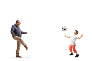 Full length profile shot of a casual mature man playing football with a boy