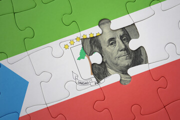 puzzle with the national flag of equatorial guinea and usa dollar banknote. finance concept