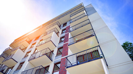 A view at a detail of a modern white apartment building with blue sky background.