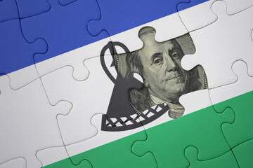 puzzle with the national flag of lesotho and usa dollar banknote. finance concept
