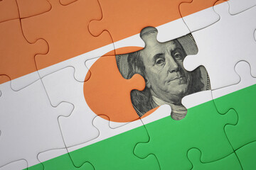 puzzle with the national flag of niger and usa dollar banknote. finance concept