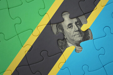 puzzle with the national flag of tanzania and usa dollar banknote. finance concept