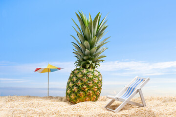 pineapple on the sand near a sun lounger and umbrella summer