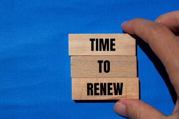 Time to renew words written on wooden blocks with blue background. Conceptual time to renew concept. Copy space.