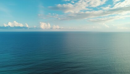 an aerial view of eternal blue sea or ocean with sunny and cloudy sky