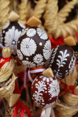 Easter background made of painted eggs and straw products, vertical frame