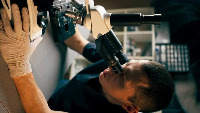 vertical video close up in a veterinary clinic a veterinarian doctor checks a smear for infections