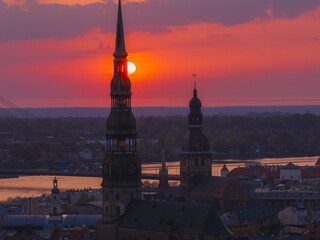 Obraz premium Magical aerial sunset over Riga old town, the capital of Latvia. Riga rooftop view panorama at sunset with urban architectures and Daugava River.