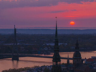 Fototapeta na wymiar Magical aerial sunset over Riga old town, the capital of Latvia. Riga rooftop view panorama at sunset with urban architectures and Daugava River.