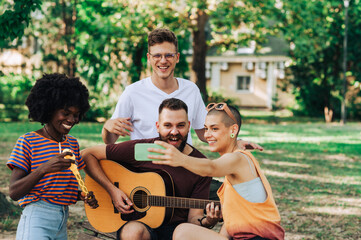 An influencer is live streaming a guitar player in park.