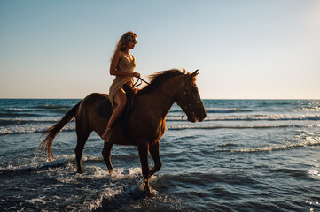 Woman riding a horse in the shallow sea water and the beach