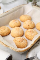 Tasty sweet sugar cookies in baking dish on white tiled table, closeup