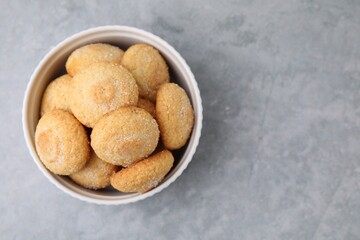 Tasty sugar cookies in bowl on grey table, top view. Space for text