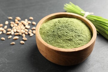 Wheat grass powder in bowl on grey table, closeup
