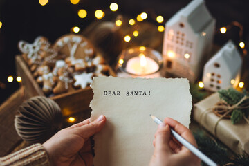 Christmas letter on craft paper to Santa Claus with text: Dear Santa. Cozy home interior with...