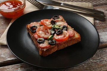 Tasty pizza toast, sauce and cutlery on wooden table, closeup