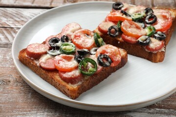 Tasty pizza toasts on wooden table, closeup