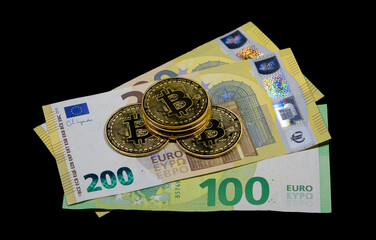 Close-up of Bitcoin coins on Euro banknotes with black background