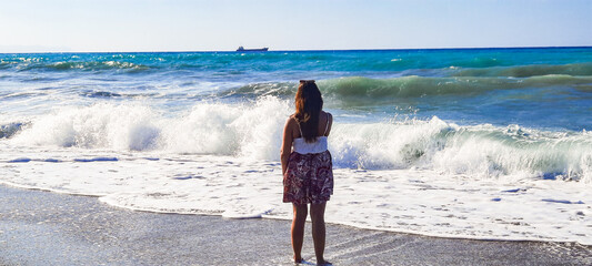 back light shinny portrait of young happy Asian woman relaxed looking at wild sea waves on sunset...