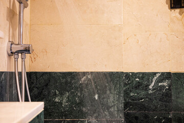 Bathroom features green tiled walls, shower head, and hardwood flooring